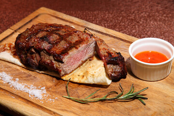 Medium-roasted steak. Medium-roasted steak cut into pieces on a wooden board.