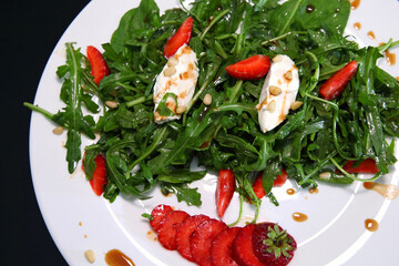 Salad with arugula, cream cheese and strawberries. Salad with arugula and strawberries. Rucola and strawberries.
