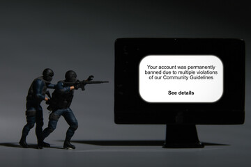 A picture of soldier miniature with desktop Community Guidelines warning in low light.