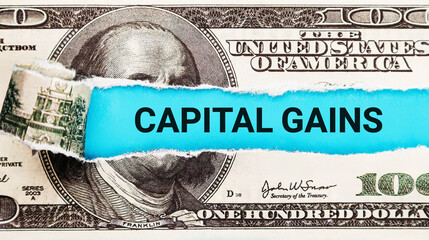 Capital Gains. The word Capital Gains in the background of the US dollar. Investment Returns, Asset...
