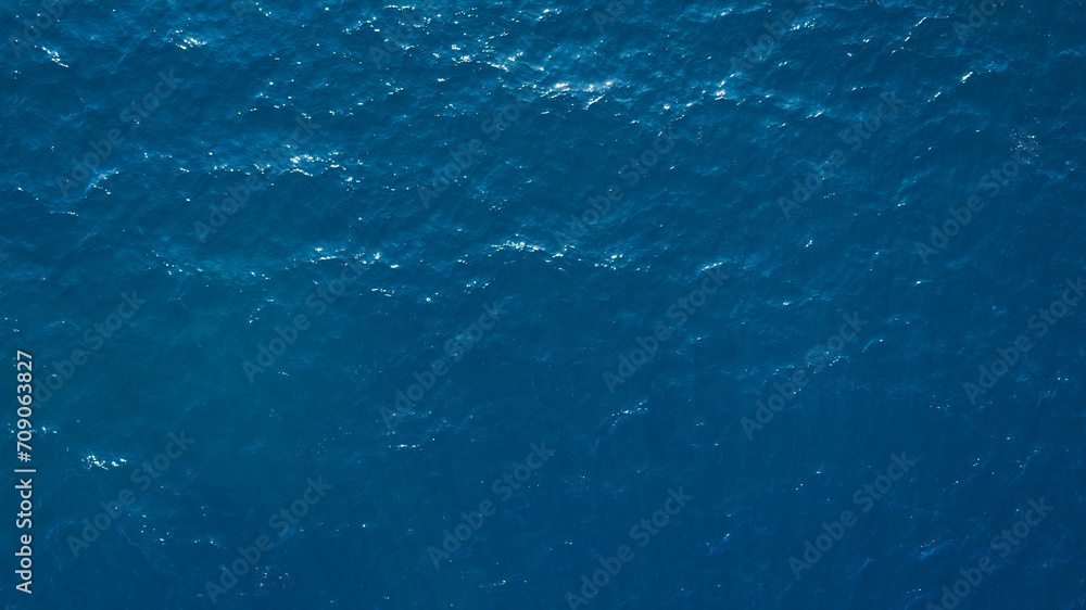 Poster Aerial View Of Surface Of deep dark blue Sea with reflection of the sun's rays as background for page, template or web banner