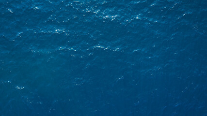 Aerial View Of Surface Of deep dark blue Sea with reflection of the sun's rays as background for page, template or web banner
