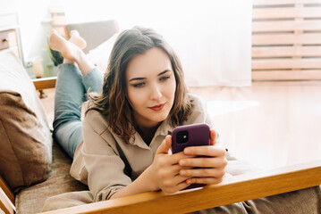 Digital Connection. Smiling Young Woman Engaged in Smartphone Typing, Social Network Chatting, and Internet Surfing. Modern Communication and Social Media Lifestyle Concept.