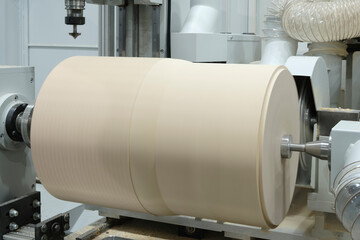 Modern woodworking lathe rotates and cuts a large wooden piece in a furniture factory, industrial concept