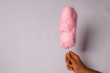 phooto of pink cotton candy on a wooden stick
