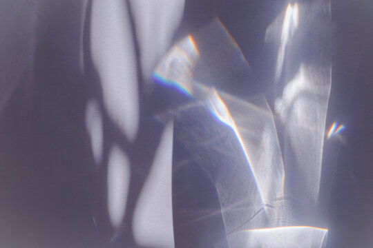 Sunlight background, abstract photo with light and shadow, glare and shine on paper texture, rainbow flare from sun, gray blue minimal aesthetic fon. Natural light and caustic effects.