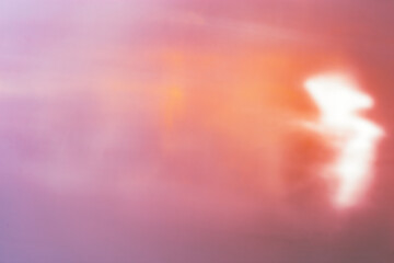 Defocused abstract orange purple background with white flare from sunlight, holiday backdrop,...