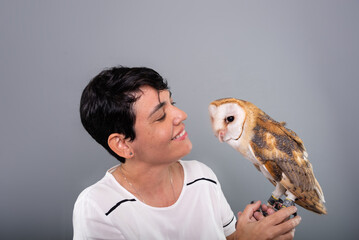 A woman lovingly looking at her owl. Wild animal.