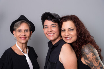 Three beautiful women, friends, members of a musical band posing for a photo.