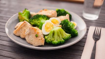 Chicken breast with broccoli and quail eggs on plate for healthy dinner