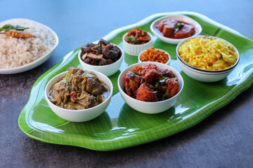 Kerala special food sadhya in banana leaf plate with Chicken fry Duck roast Beef fry Fish curry Cabbage thoran. Festival food for Christmas Easter celebration Kerala India Sri Lanka
