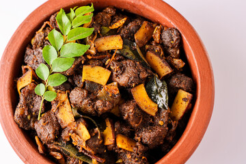 Spicy red beef fry curry and brown rice South Indian dish Kerala, India. side of Ghee rice, Appam, Parotta, Puttu. traditional Christian Muslim feast dish. Buffalo roast, meat pepper fry with coconut.