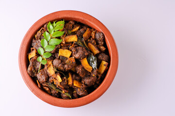 Spicy red beef fry curry and brown rice South Indian dish Kerala, India. side of Ghee rice, Appam, Parotta, Puttu. traditional Christian Muslim feast dish. Buffalo roast, meat pepper fry with coconut.