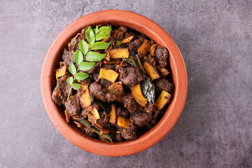 Spicy red beef fry curry and brown rice South Indian dish Kerala, India. side of Ghee rice, Appam, Parotta, Puttu. traditional Christian Muslim feast dish. Buffalo roast, meat pepper fry with coconut.