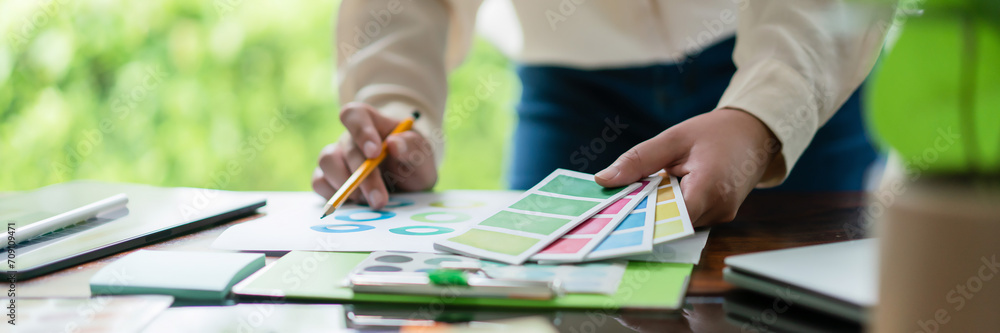 Poster creative graphic designer holding color swatch to comparing color on document for designing project