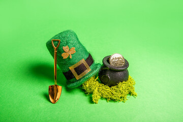 On green isolated background St. Patricks hat, leprechaun kettle with gold coins, shovel, horseshoe...