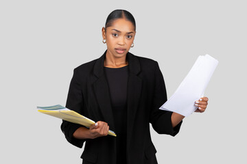 Serious African American businesswoman holding documents and a folder