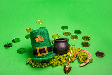 Gold coins scattered on green isolated background, St. Patricks hat, leprechaun kettle, shovel,...