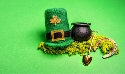 On green isolated background St. Patricks hat, leprechaun kettle with gold coins, shovel, horseshoe...
