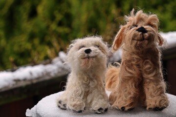 Zwei nadelgefilzte Goldendoodle aus Hundehaaren im Schnee.