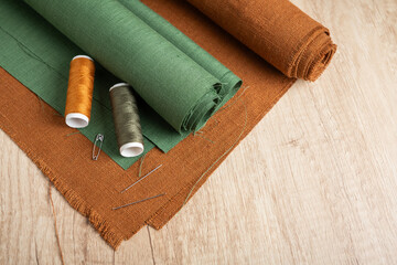Green and tan fabric with needles and threads - 709123421