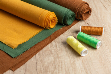 Clothing industry background, colorful linen textile on wooden table - 709123425