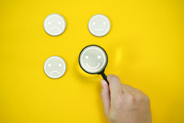 Magnifying focus on smile face icon, concept of Customer review good rating for positive customer...