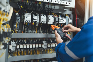Electrician measurements with multimeter testing current electric in control panel, safety concept .