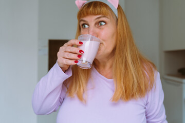 Middle aged woman drinking yogurt