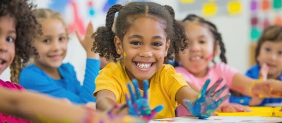 Hands-on learning: Children delight in finger painting in art class. - obrazy, fototapety, plakaty