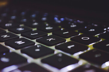 Laptop keyboard with light on table.