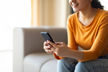 Happy Young Woman Texting On Smartphone While Relaxing On Couch At Home