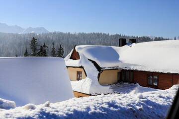 BUKOWINA TATRZANSKA, POLAND - FEBRUARY 09, 2023: W wooden home under the snow in Bukowina Tatrzanska, Poland.