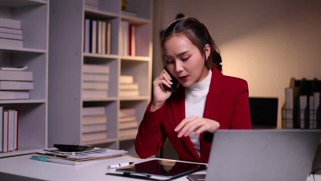 I dont want to hear excuses, just get it done. Serious Asian businesswoman talking on a mobile phone during a late night at work.