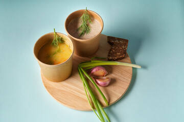 Pea soup and Mushroom cream soup in paper disposable cups for take-out or delivery of food.