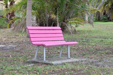 pink painted bench in the park to sit on