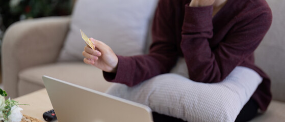 Young Asian woman hands holding credit card and using laptop for internet purchase. Online...
