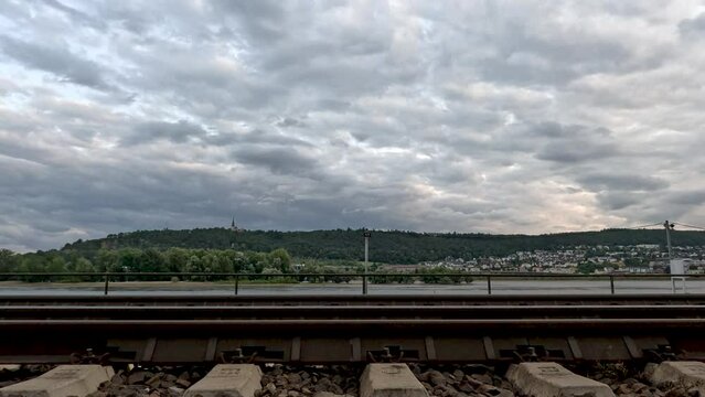 Railroad tracks run along the shoreline of the Rhine River. Stunning waterfront views in R&uuml;desheim, Germany. R&uuml;desheim is a town on the northern banks of the Rhine river in the German wine region.