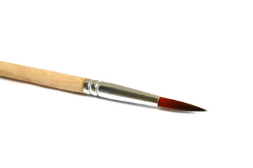  A wooden brush for painting lies on a white background.