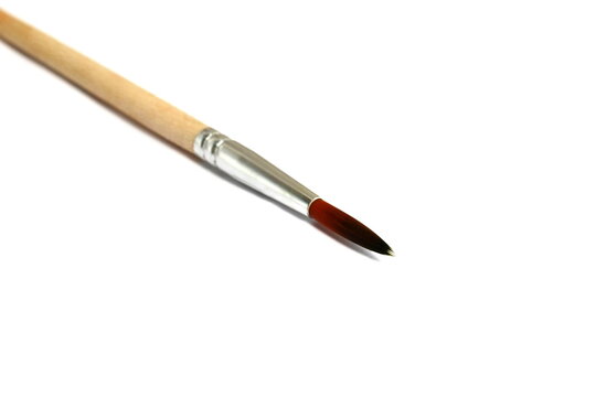 A wooden brush for painting lies on a white background.