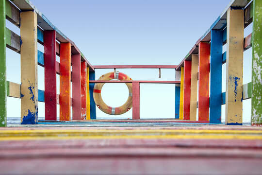 The end of the colorful footbridge with a lifebuoy