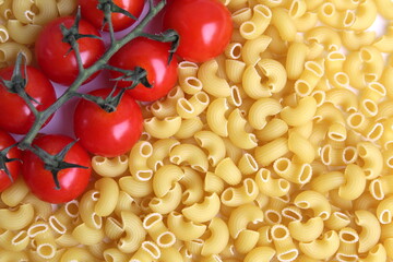 Background of pasta and cherry tomatoes on a branch.