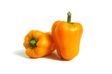 Two yellow peppers lie on a white background.