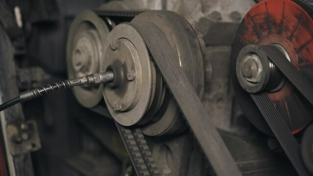 A mechanic injects grease into the engine cooling system - the water pump bearing. Close-up