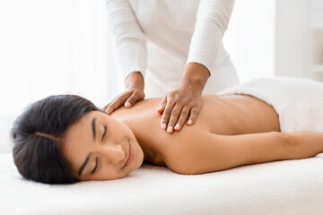 Obraz na płótnie Canvas Content hindu woman receiving a soothing back massage