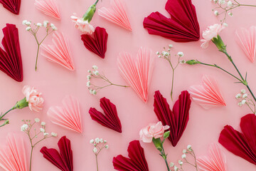 Valentines day flat lay. Stylish pink and red hearts composition with flowers on pink background....