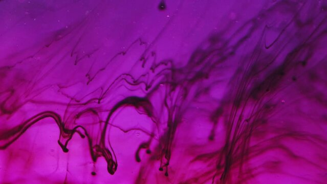 Ink drop background. Dye fluid. Abstract contamination art. Dirty mud black substance flowing with bubbles and blur bokeh particles in purple ocean water.