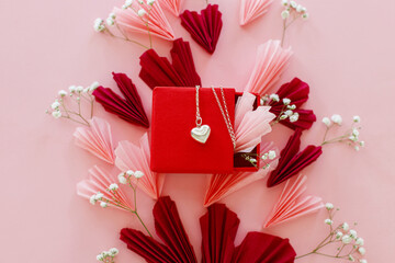 Happy Valentine's day ! Stylish pink and red hearts, flowers and heart necklace flat lay on pink...