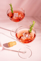 Top view of refreshing cocktail with rosemary in a glass on a bright background. Summer party concept.
