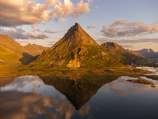 The Volandstind Mountain in Lofoten, with its reflection in the calm sea, at sunset, near Ramberg